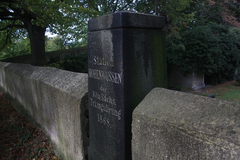 Die Vermessungsaäule ist in eine Kirchhofs-/Friedhofsmauer integriert.