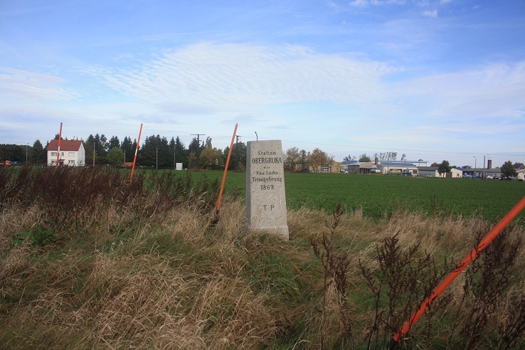 Die Vermessungsa&auml;ule steht auf einem Feld.